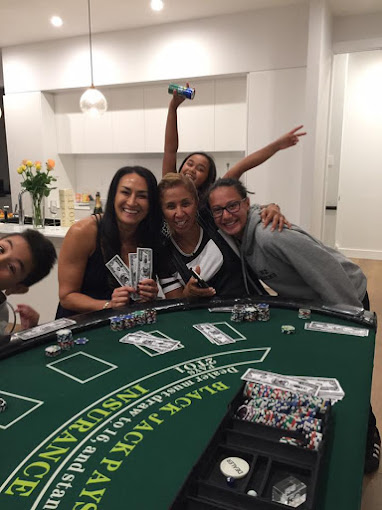Friends enjoying casino night entertainment with blackjack table hire in Auckland