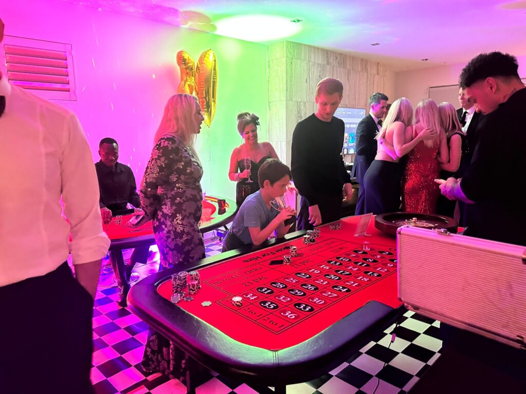 a group of people around a roulette table during birthday party